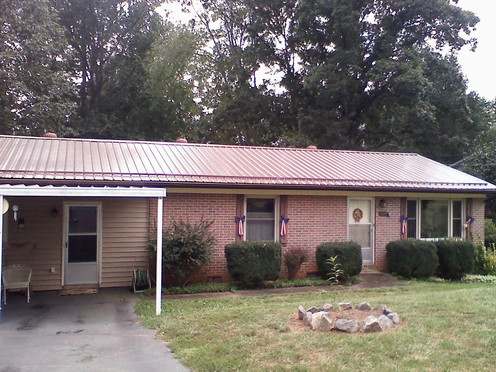 Bronze metal roof and carport on a brick ranch home — Roof Repair work by our crew in Cartersville